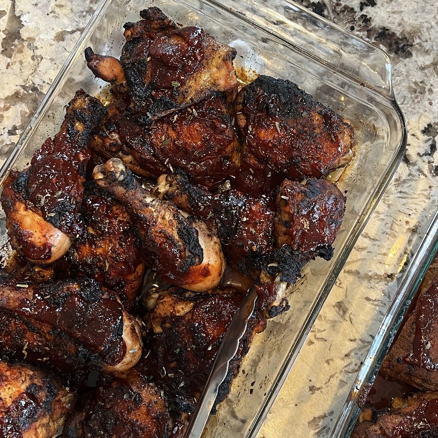 Charred, sauced barbecue chicken in a baking dish