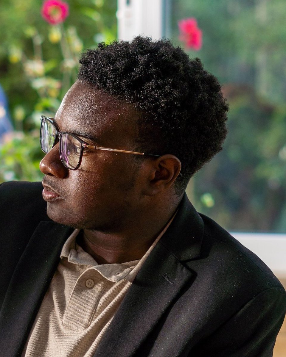 Ace Cofield in a black blazer, looking out the window